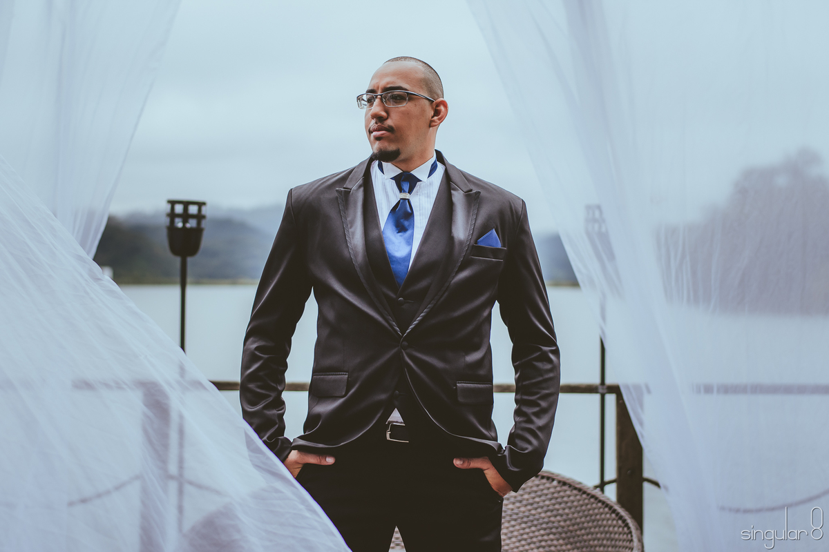 Noivo com terno preto e gravata azul marinho