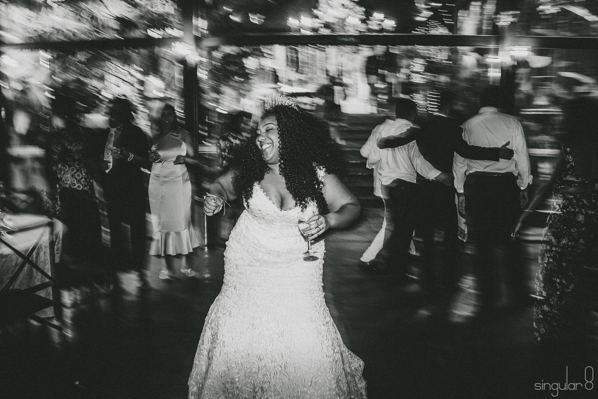 Noiva negra cacheada com vestido sereia dançando em casamento de dia