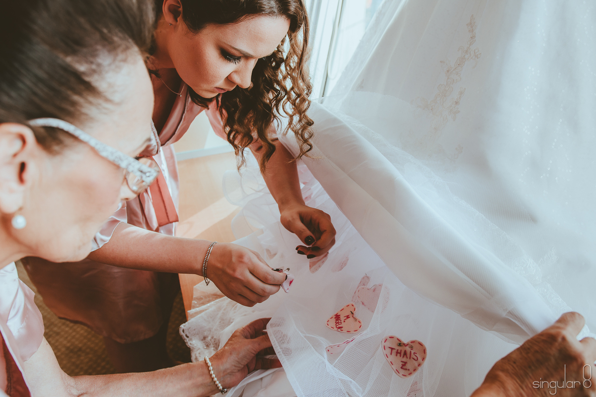Nomes de solteiras na barra do vestido da noiva com coração de feltro e costura