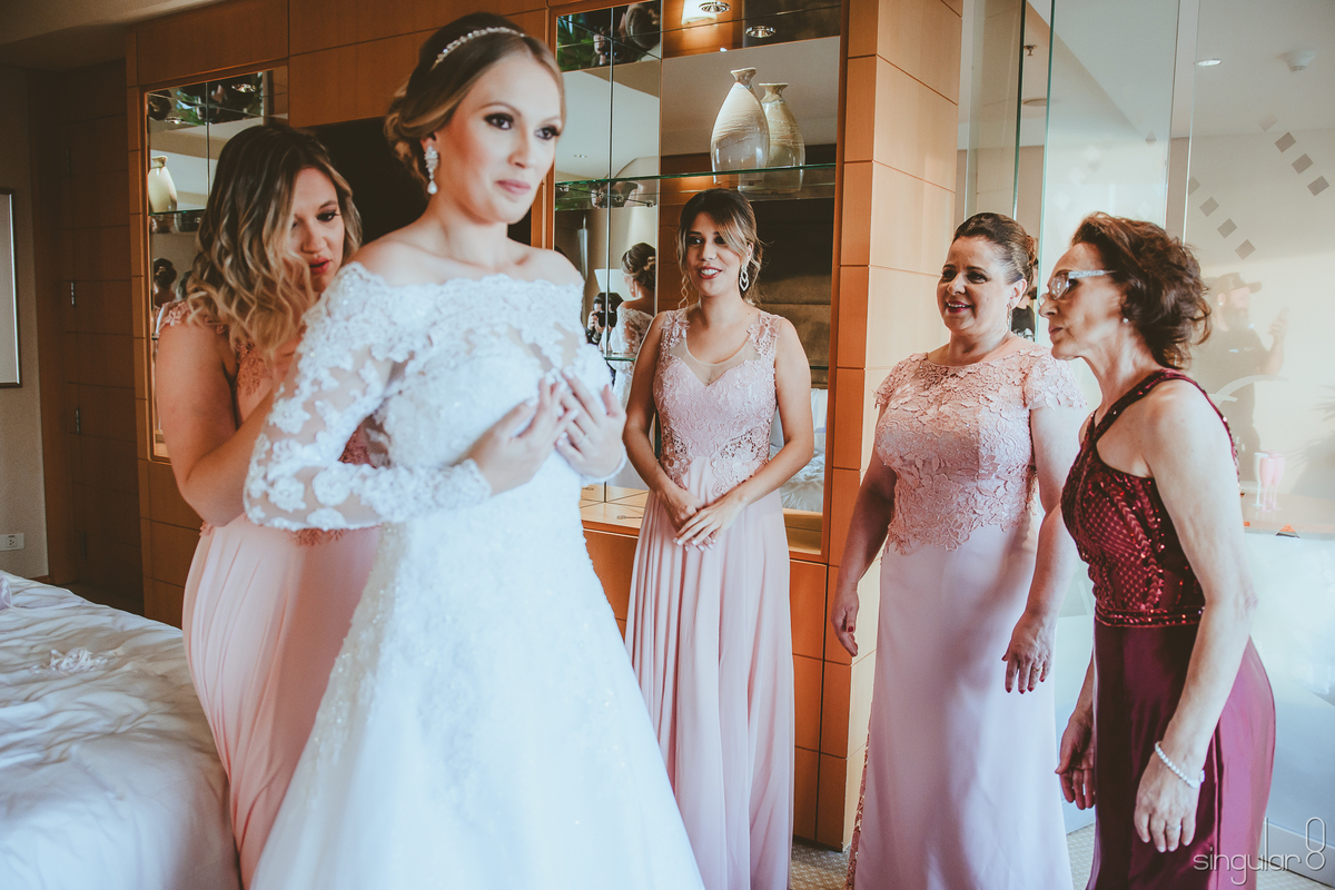 Madrinha ajudando a noiva a vestir o vestido no making of no Hotel Hilton Morumbi