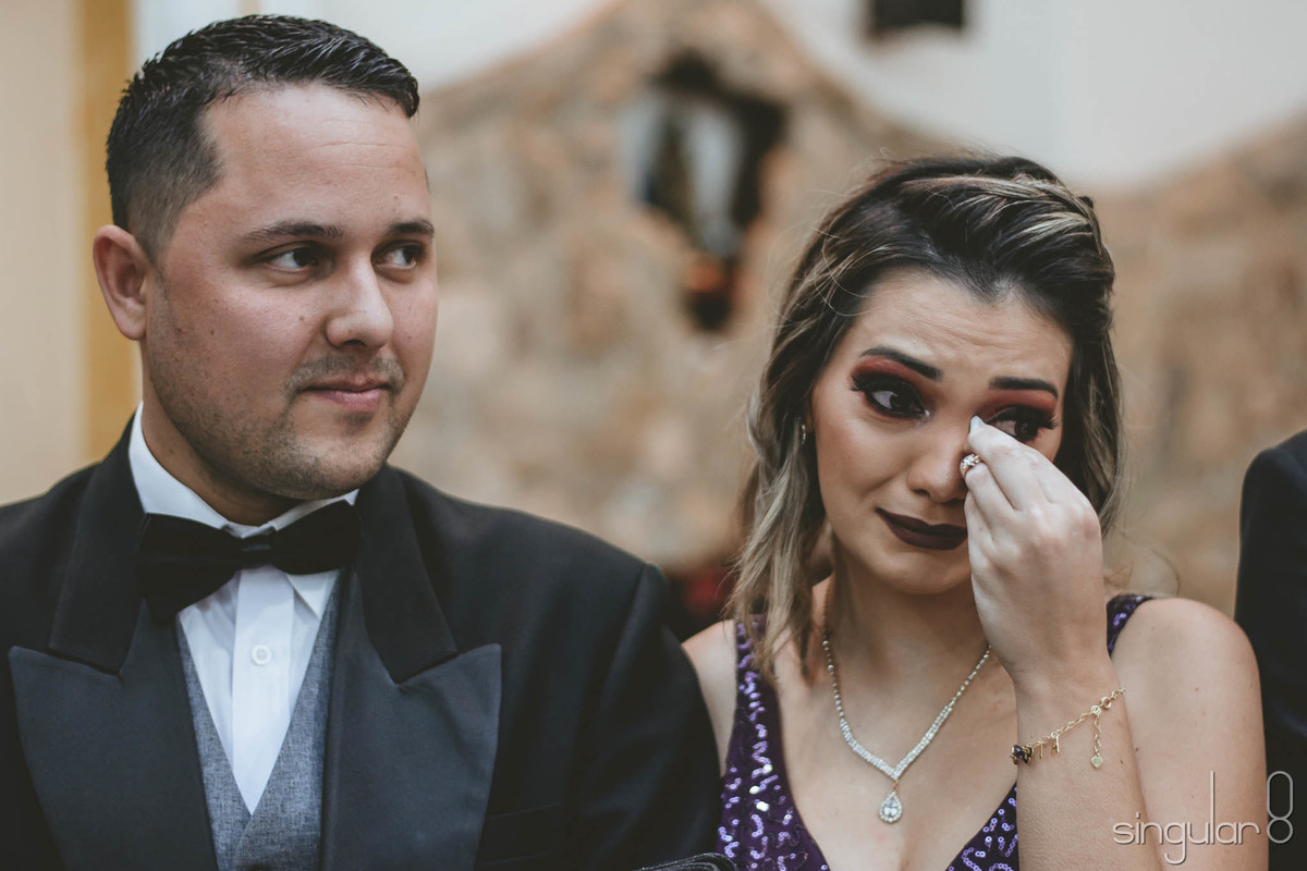 Foto da madrinha emocionada com os votos de casamento escritos pelos noivos para a cerimônia religiosa