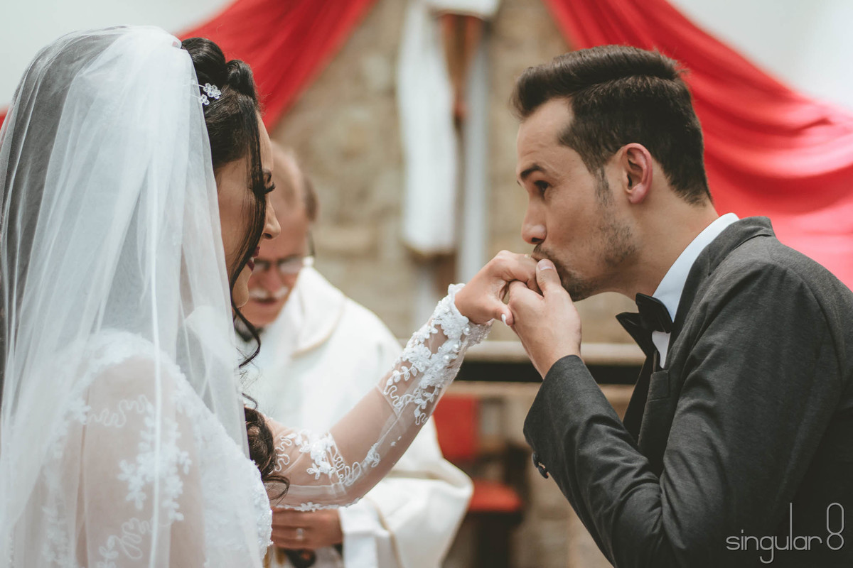 Noivos colocando as alianças na cerimônia religiosa de casamento