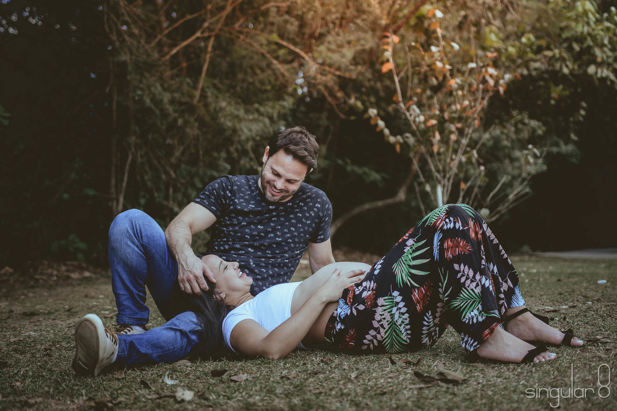 Grávida deitada na grama do Parque Centenário para ensaio