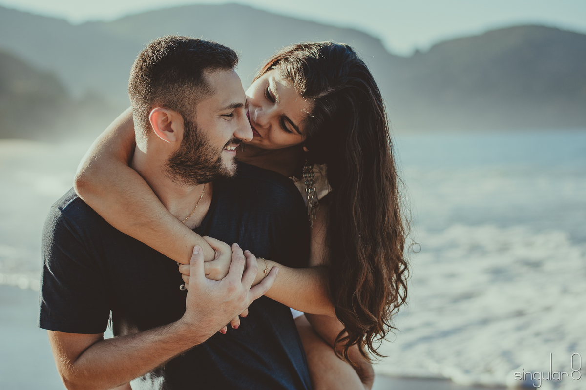 Casal em ensaio pré casamento na praia com o dia amanhecendo