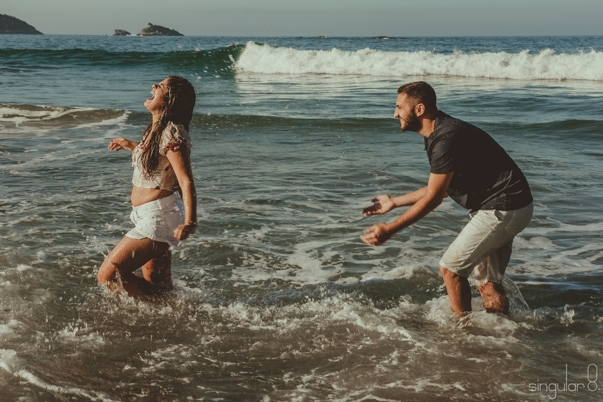 Casal brincando na água em ensaio pré casamento em Bertioga