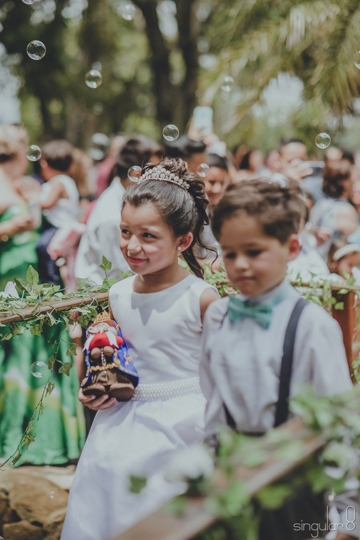 Filha da noiva entrando com as alianças na cerimônia