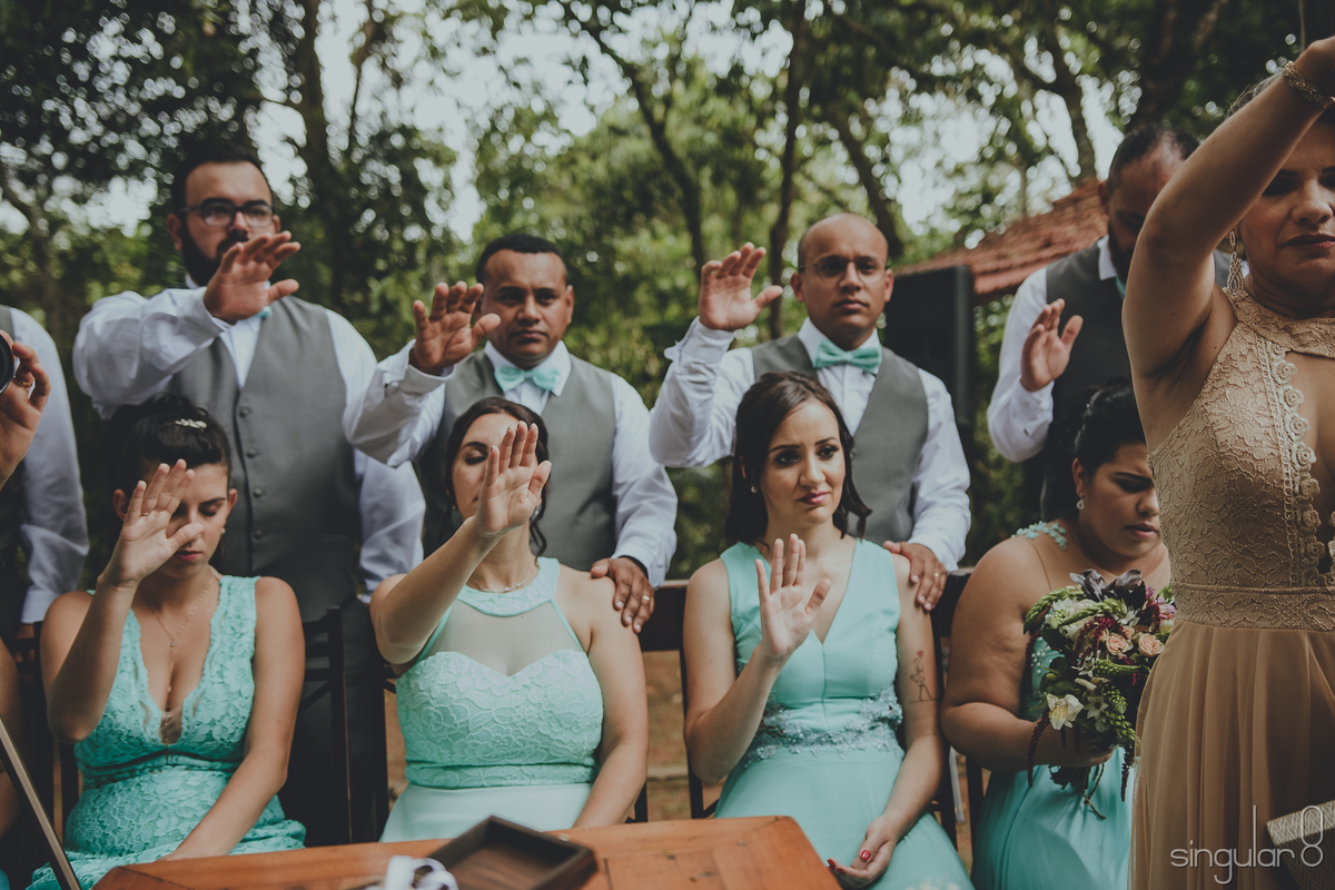 Padrinhos e madrinhas orando pelos casais em casamento duplo
