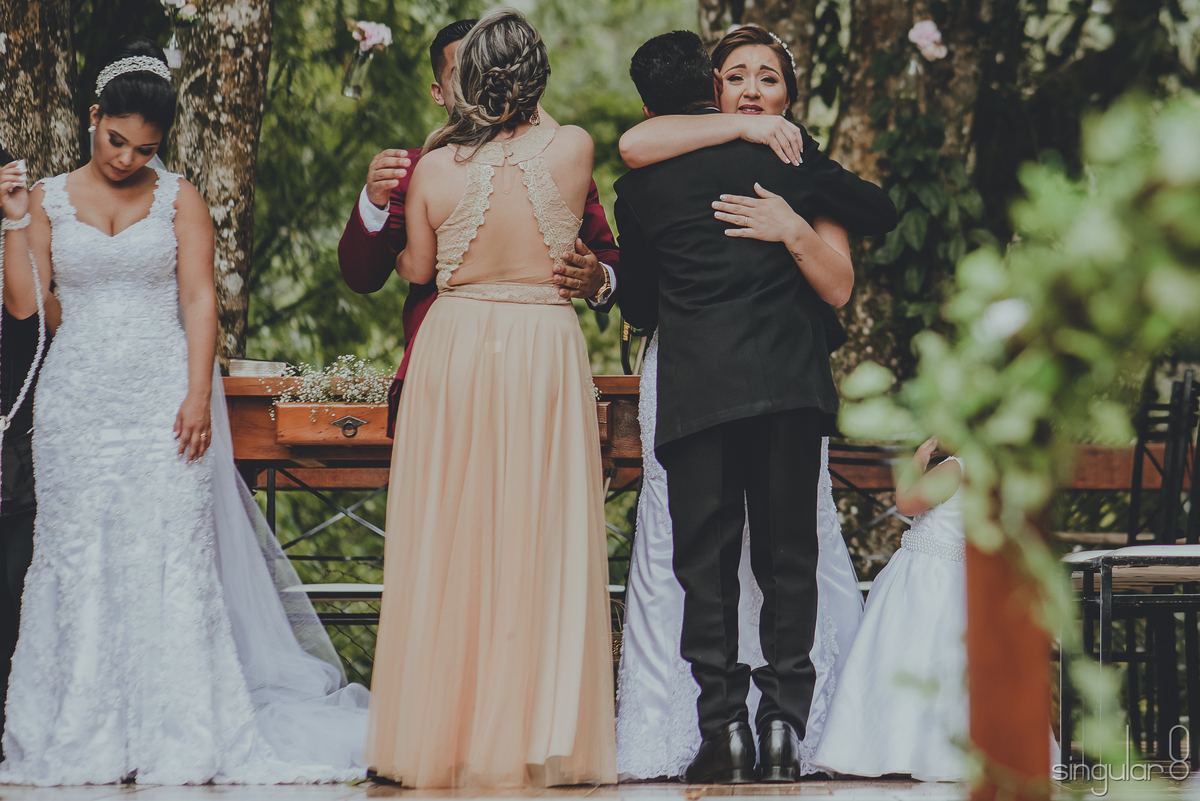 Fotografia dos cumprimentos dos pais nos noivos após cerimônia religiosa