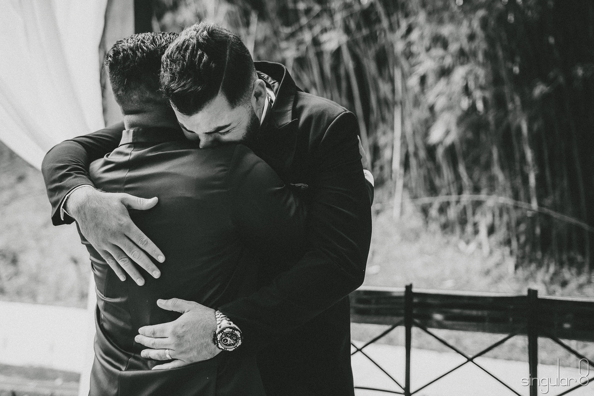 abraço emocionante entre cunhados pós cerimônia religiosa em casamento de dia no sítio Della Torre