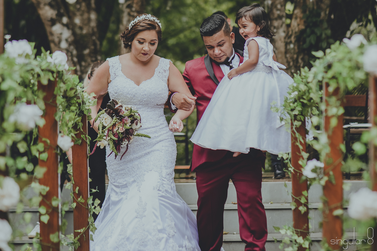 Saída dos noivos no casamento com a filha no colo
