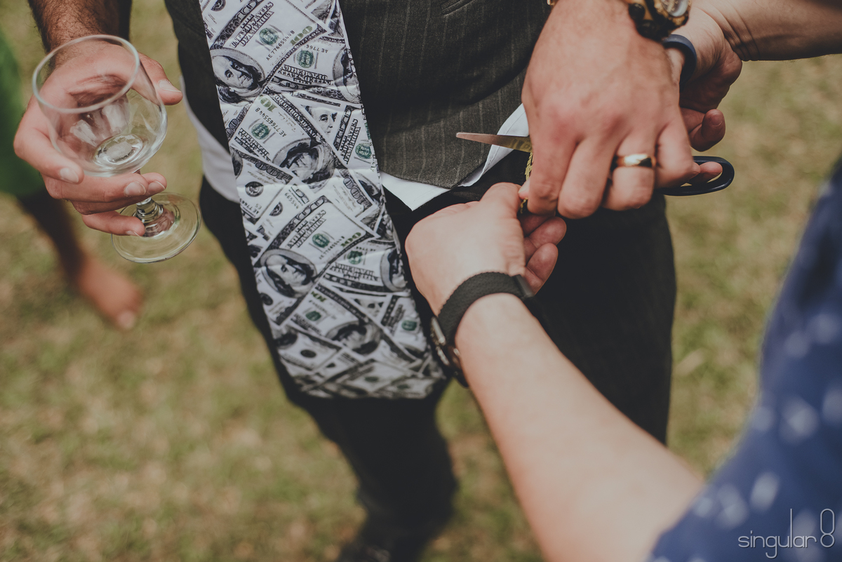 Padrinhos cortando a cueca do noivo por dinheiro em casamento