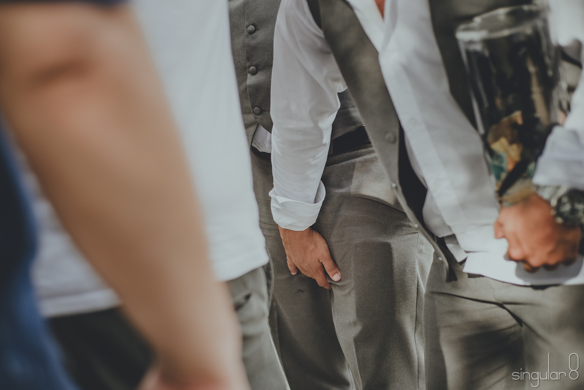 Noivos passando a gravata em casamento duplo