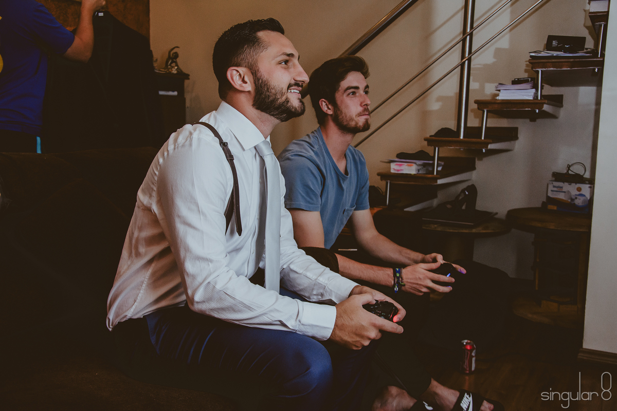 noivo jogando video game com os padrinhos antes de ir para cerimônia de casamento