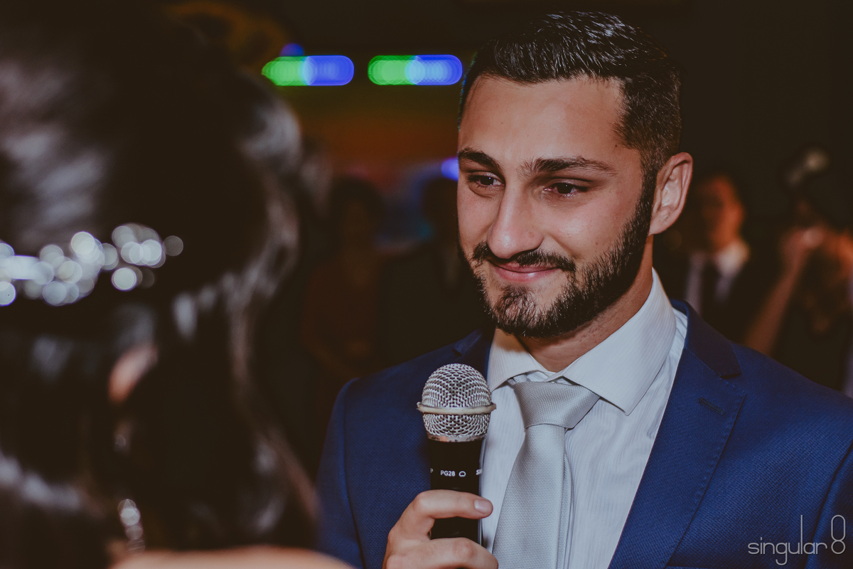 Fotografa de noivo com terno azul e gravata branca emocionado com os votos de casamento