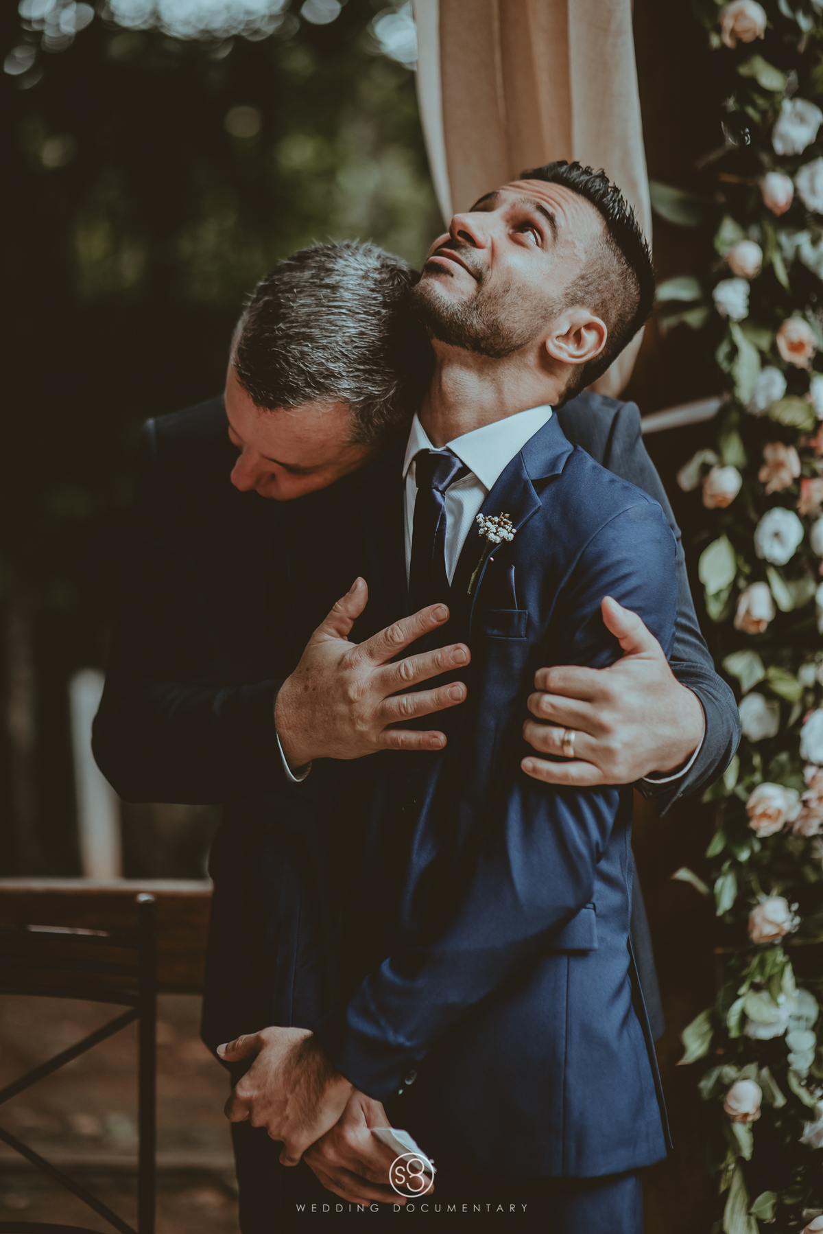 Fotografia de casamento do noivo abraçando o irmão no Sítio Della Torre