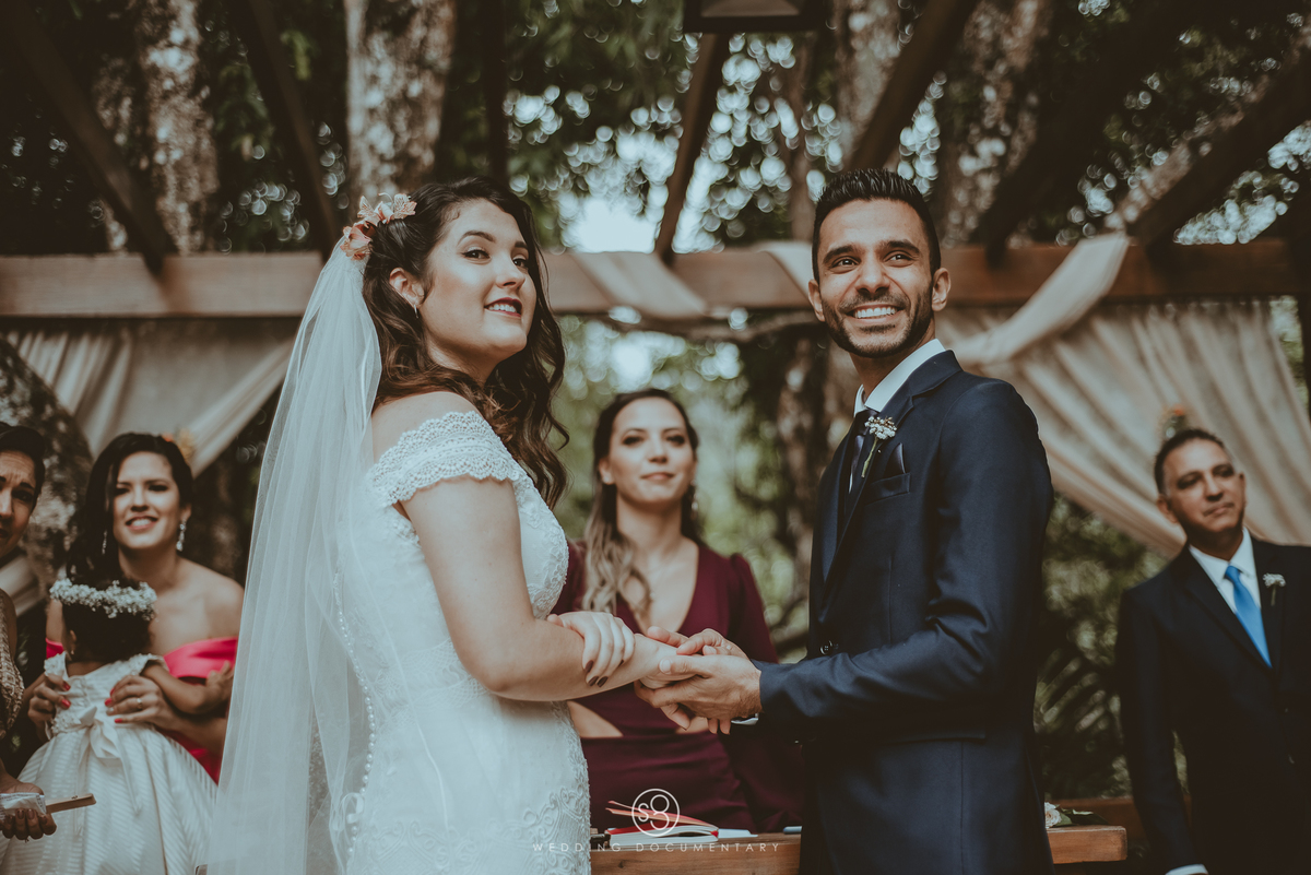 Fotografia da reação dos noivos na entrada das alianças em casamento de dia