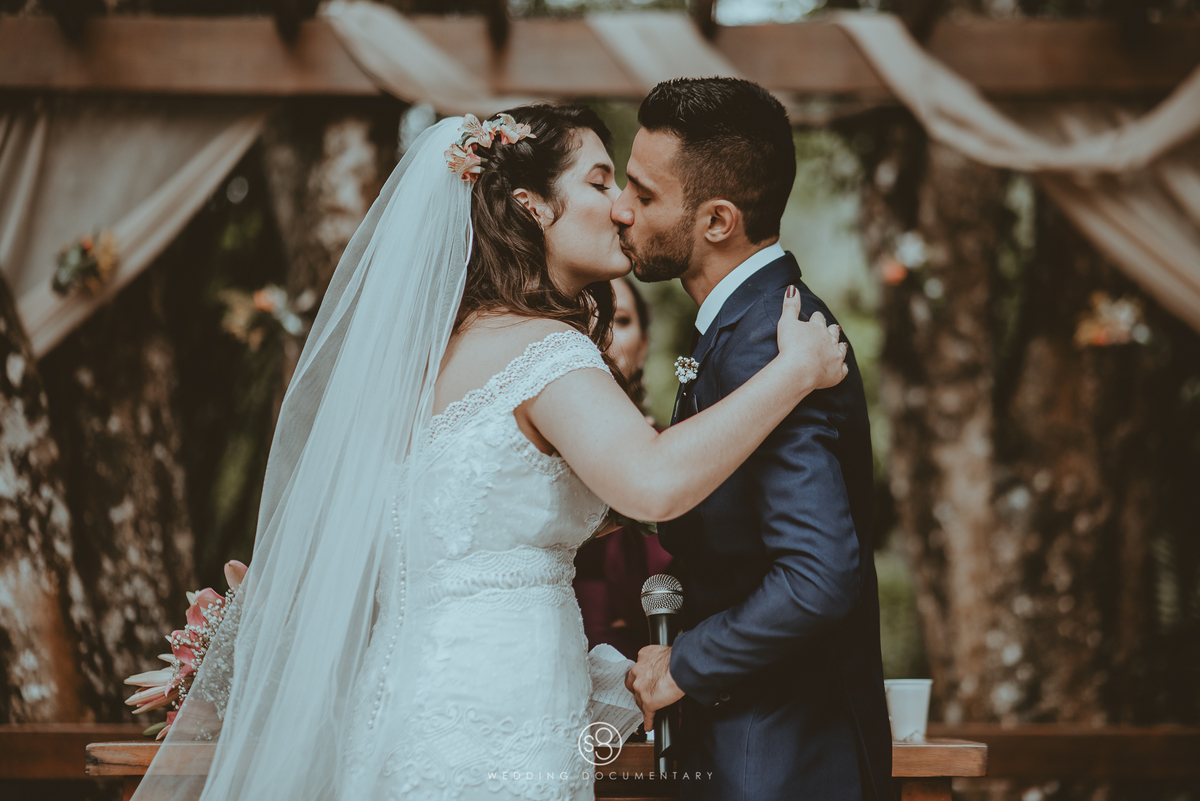 Fotografia do beijo dos noivos em casamento de dia no Sítio Della Torre