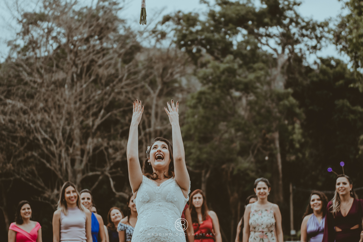 Fotografia diferente da noiva jogando o bouquet em casamento de dia no sítio Della Torre