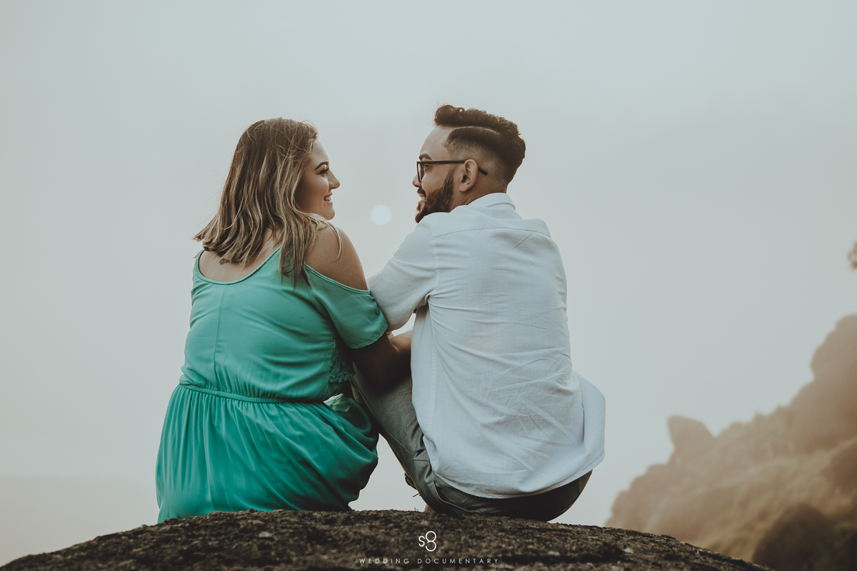 Fotografia de casal sentado no ensaio pré casamento no pico do olho d'agua em Mairiporã no amanhecer