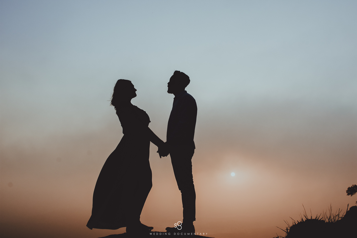 Fotografia de silhueta do casal no no pico do olho d'agua em Mairiporã no amanhecer