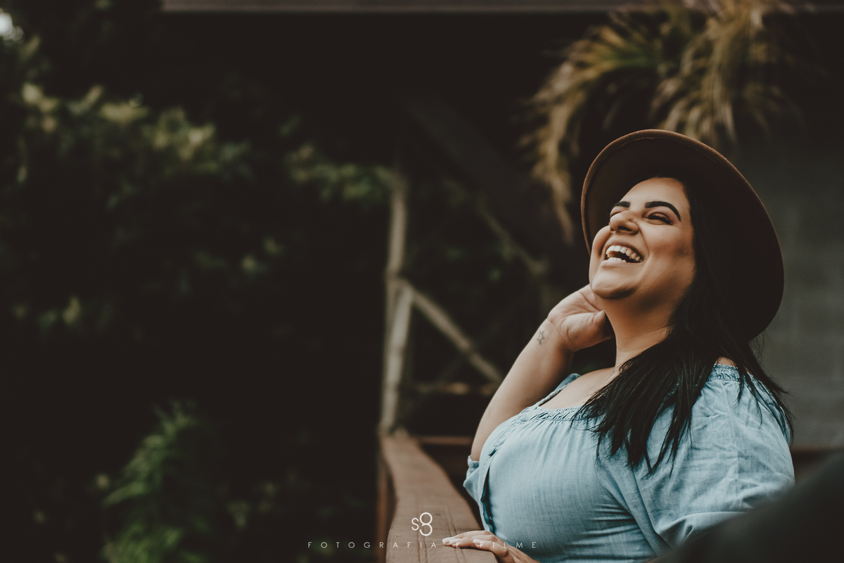 Fotografia de noiva sorrindo com roupa jeans em ensaio no Deck Steak House Mairiporã