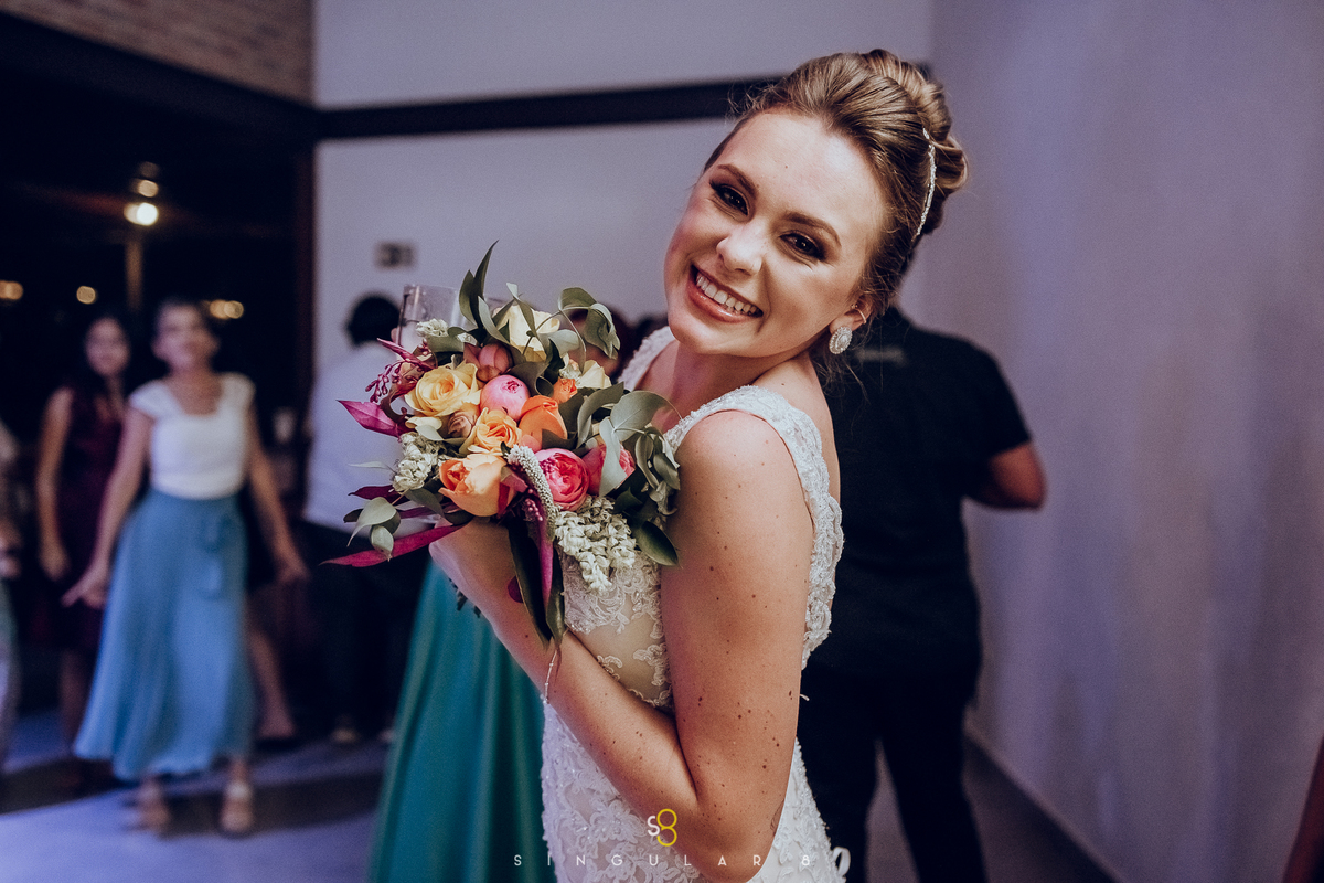 Fotos de casamento da noiva jogando o buquê a noite na pista do Recanto Callegari