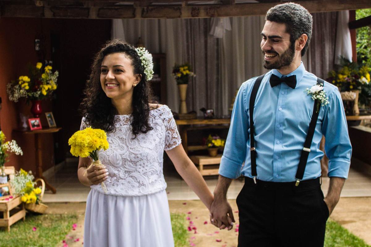 fotografia da entrada dos noivos juntos de mãos dadas em casamento realizado na cidade de Jampruca, Minas Gerais