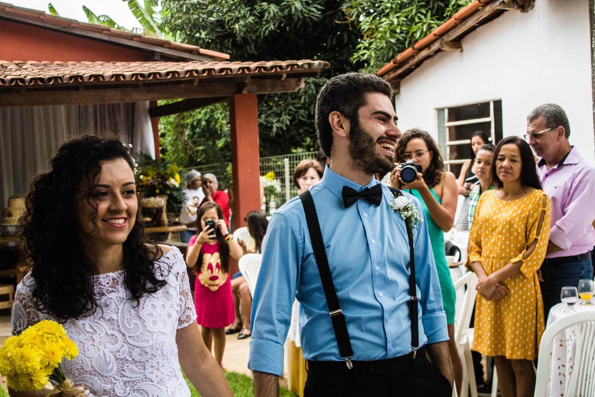 fotografia da entrada dos noivos sorrindo em casamento realizado na cidade de Jampruca, Minas Gerais
