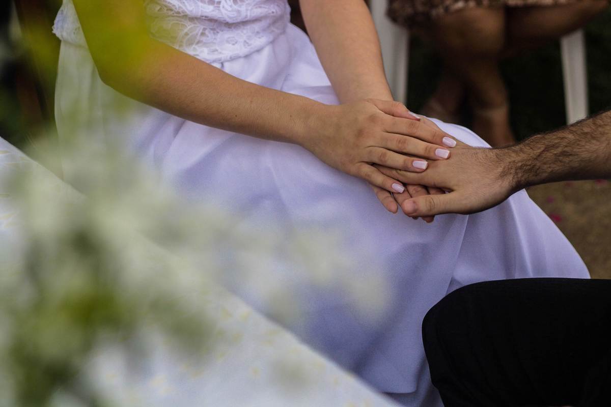 fotografia das mãos noiva fazendo carinho na mão do noivos em casamento realizado na cidade de Jampruca, Minas Gerais