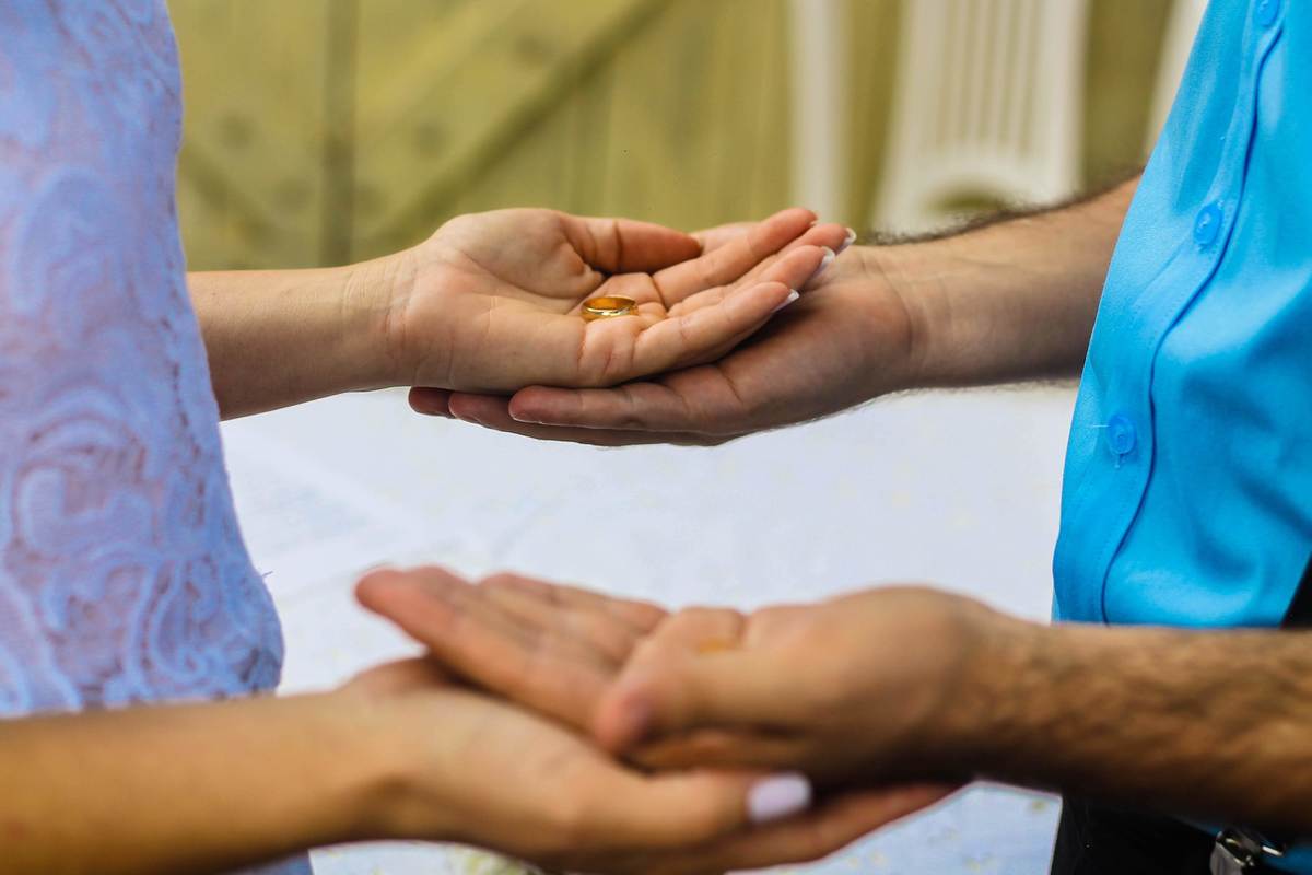 fotografia das mãos dos noivos com aliança em casamento realizado na cidade de Jampruca, Minas Gerais