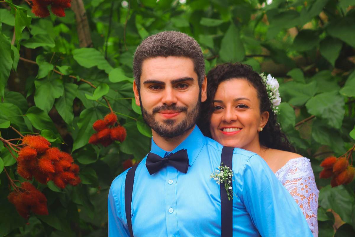 Fotografia dos noivos abraçados próximo a árvore de urucu durante ensaio fotográfico pós casamento realizado na cidade de Jampruca Minas Gerais 