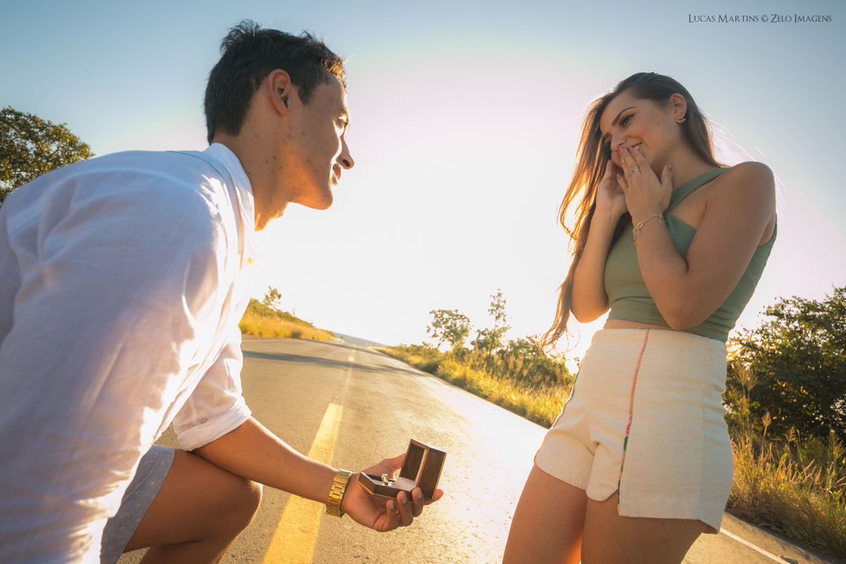 noivo pedindo a noiva em casamento ajoelhado com as aliancas na mao