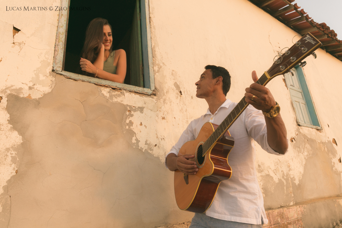 noivo fazendo serenata para a noiva na janela da casinha na roca