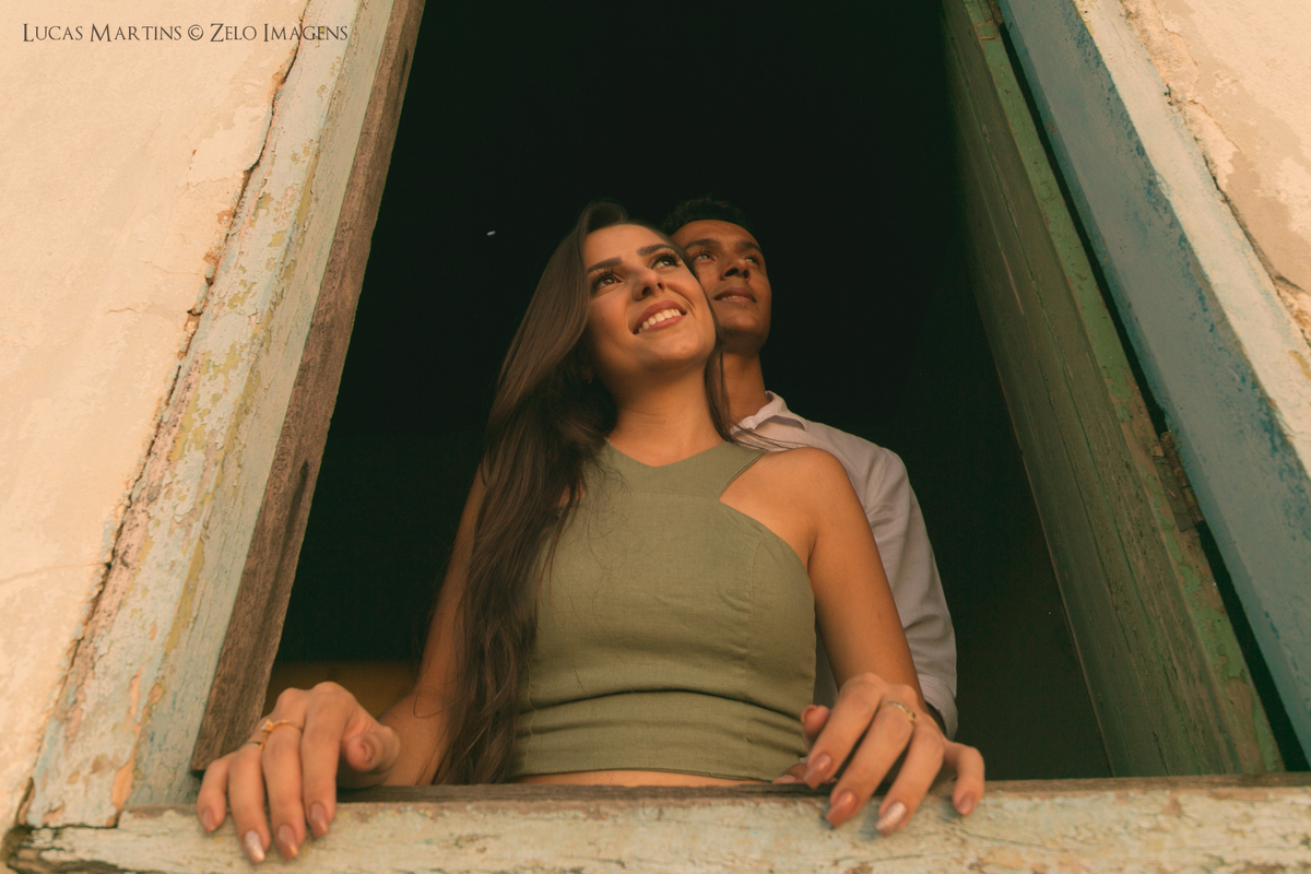 casal posa na janela da casinha da roca