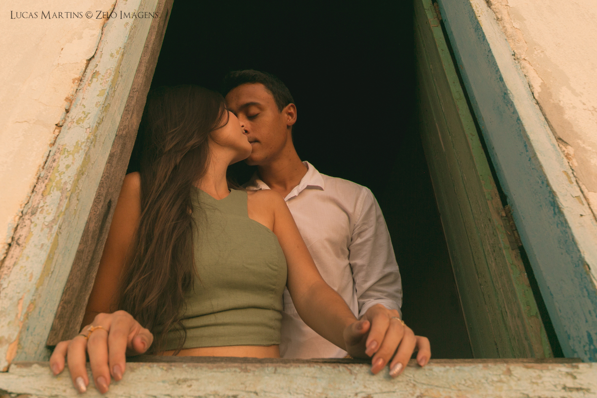 casal posa na janela da casinha da roca