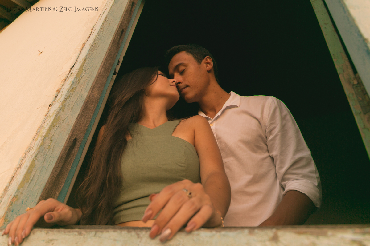 casal posa na janela da casinha da roca