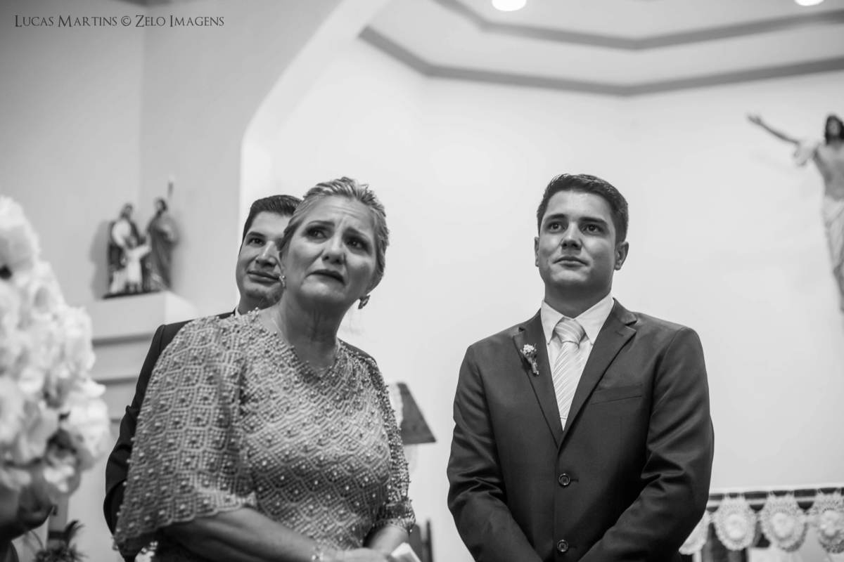 Fotografia do noivo e sua mãe olhando a entrada da noiva em casamento realizado na cidade de Virgem da Lapa - MG