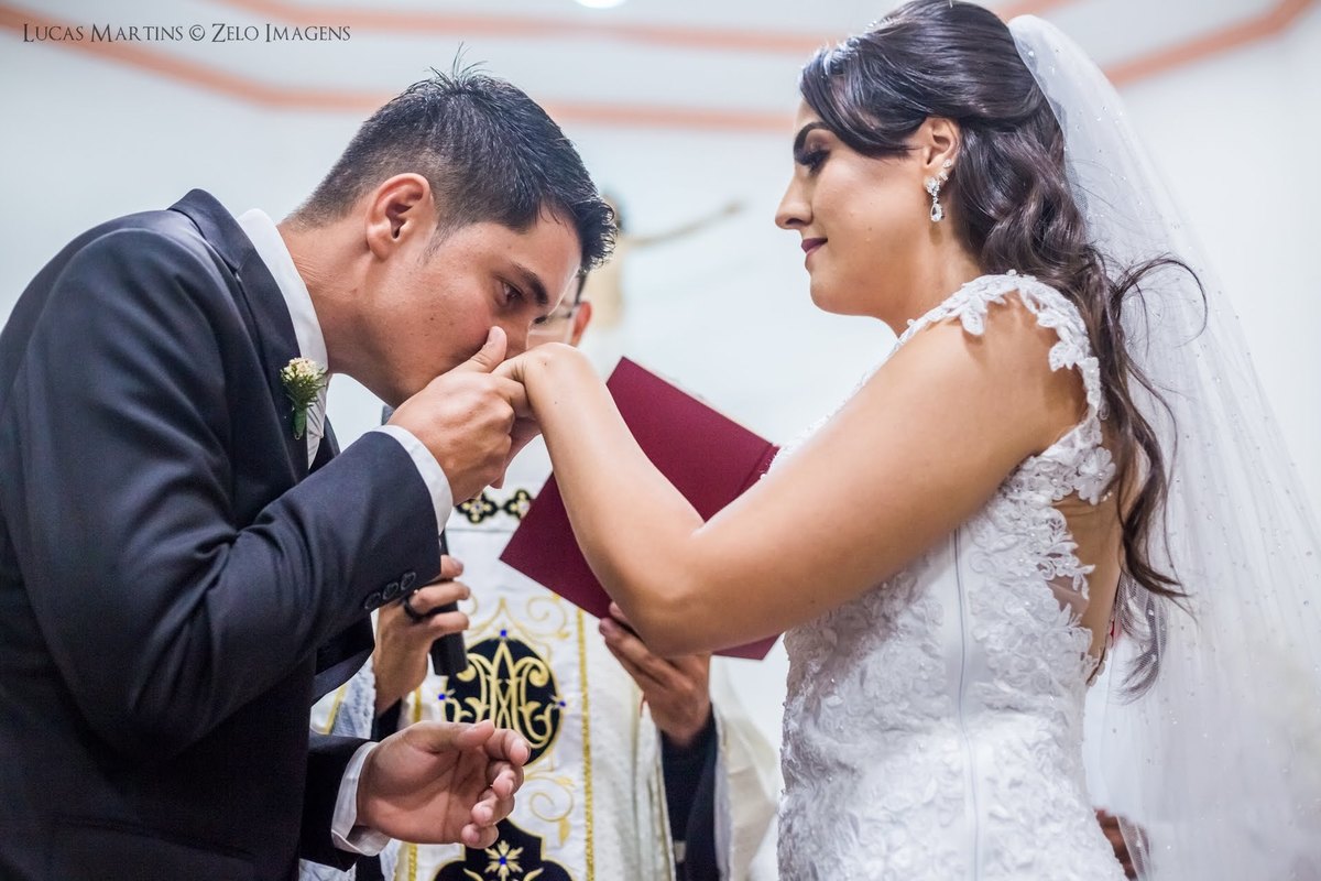 fotografia do noivo beijando a mão da noiva após a troca de alianças em casamento em cerimônia de casamento