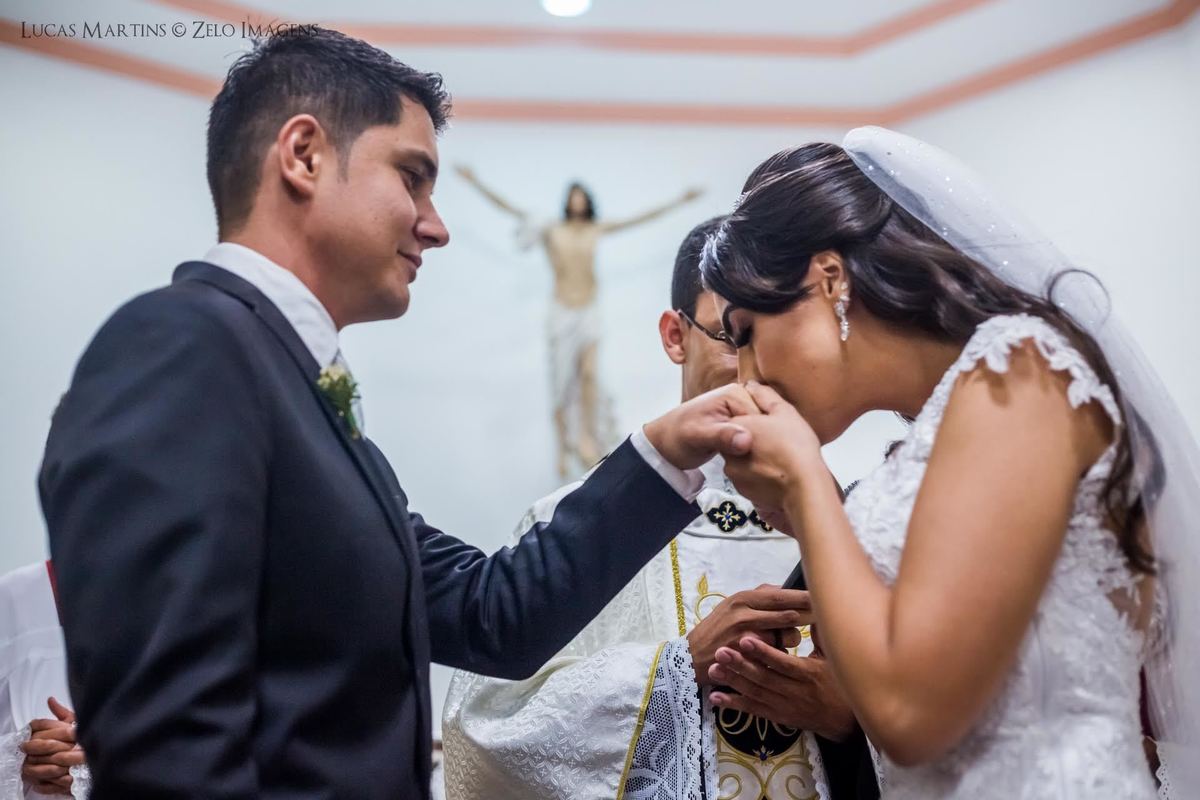 fotografia da noiva beijando a mão do noivo após a troca de alianças em casamento em cerimônia de casamento na cidade de Virgem da Lapa.