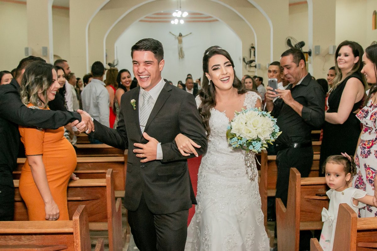 fotografia de convidado apertando a mão do noivo durante a saída dos noivos.