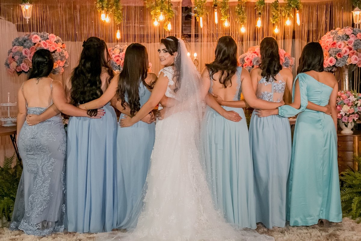 fotografia das madrinhas com a noiva de costas, a noiva com vestido de noiva olhando para a foto e o vestido das madrinhas da cor azul
