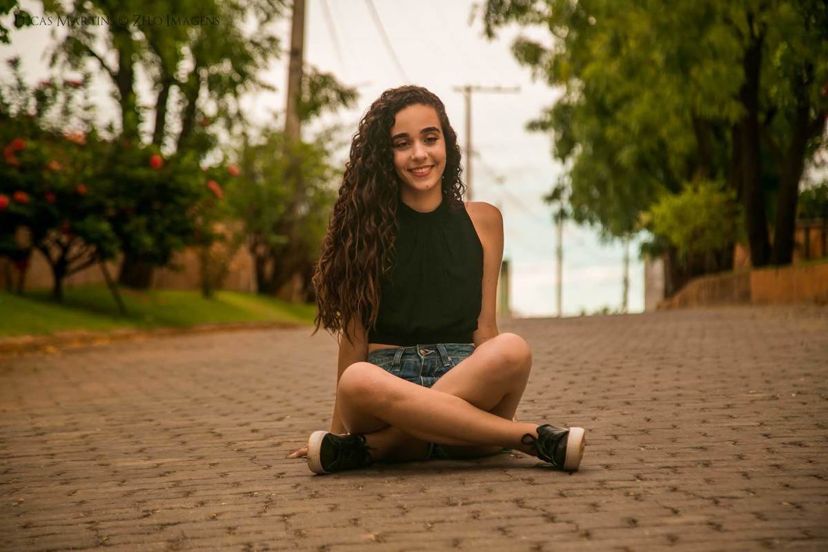 Debutante sorrindo sentada no chão