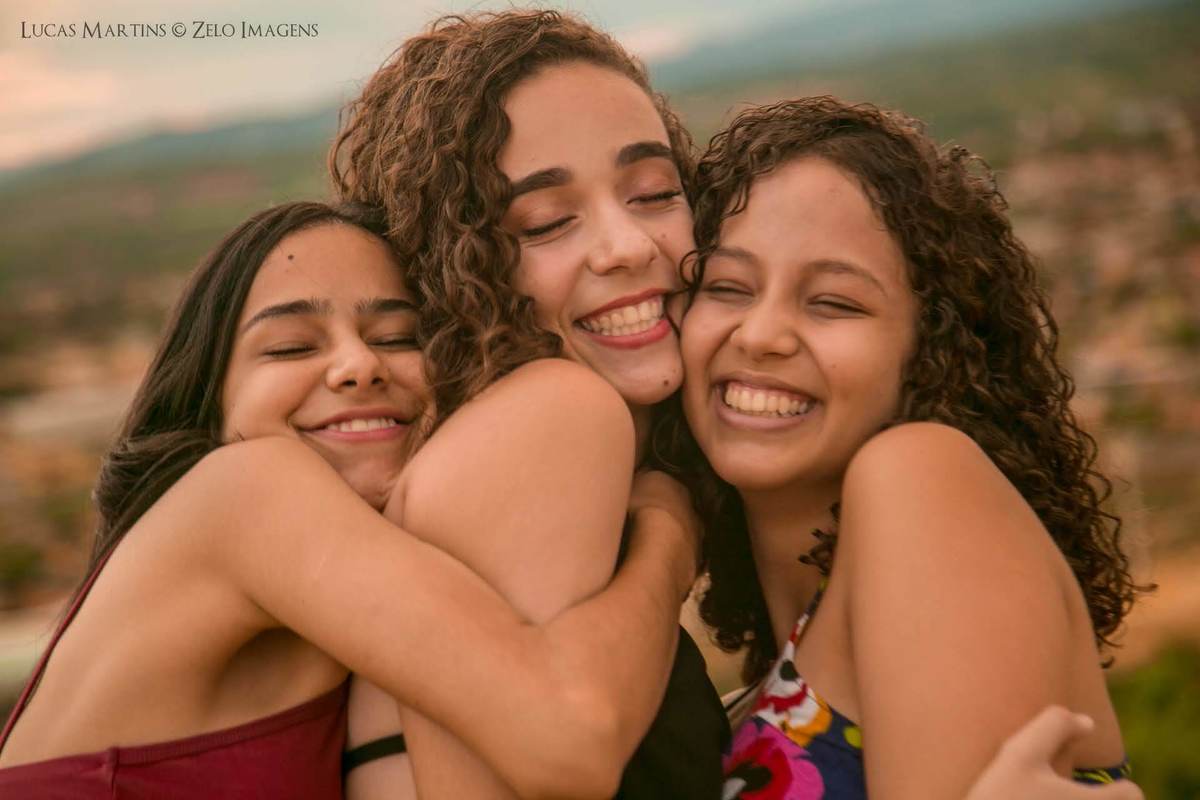 debutante sorrindo com as 3 amigas e a cidade ao fundo