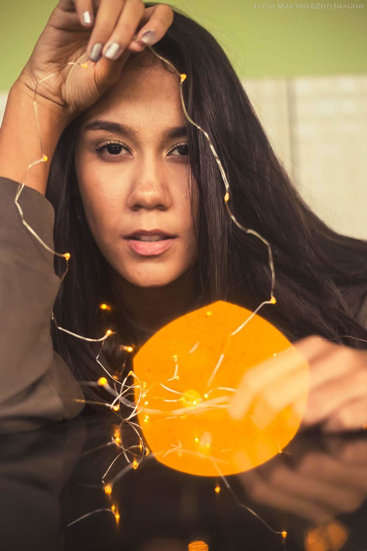 Fotografia de debutante com luzes, fio de fada, durante ensaio fotográfico 15 anos em Virgem da Lapa, Minas Gerais.