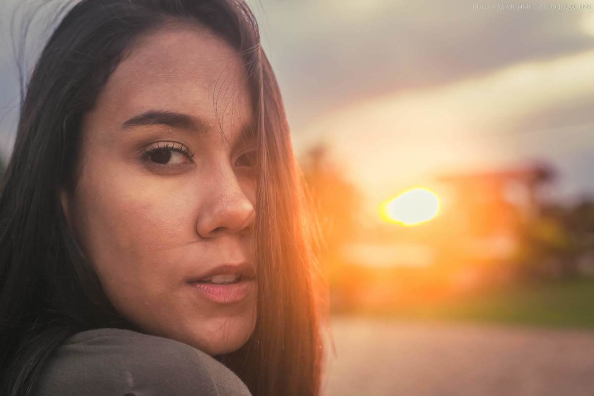 fotografia de debutante , close no rosto, com por do sol ao fundo.