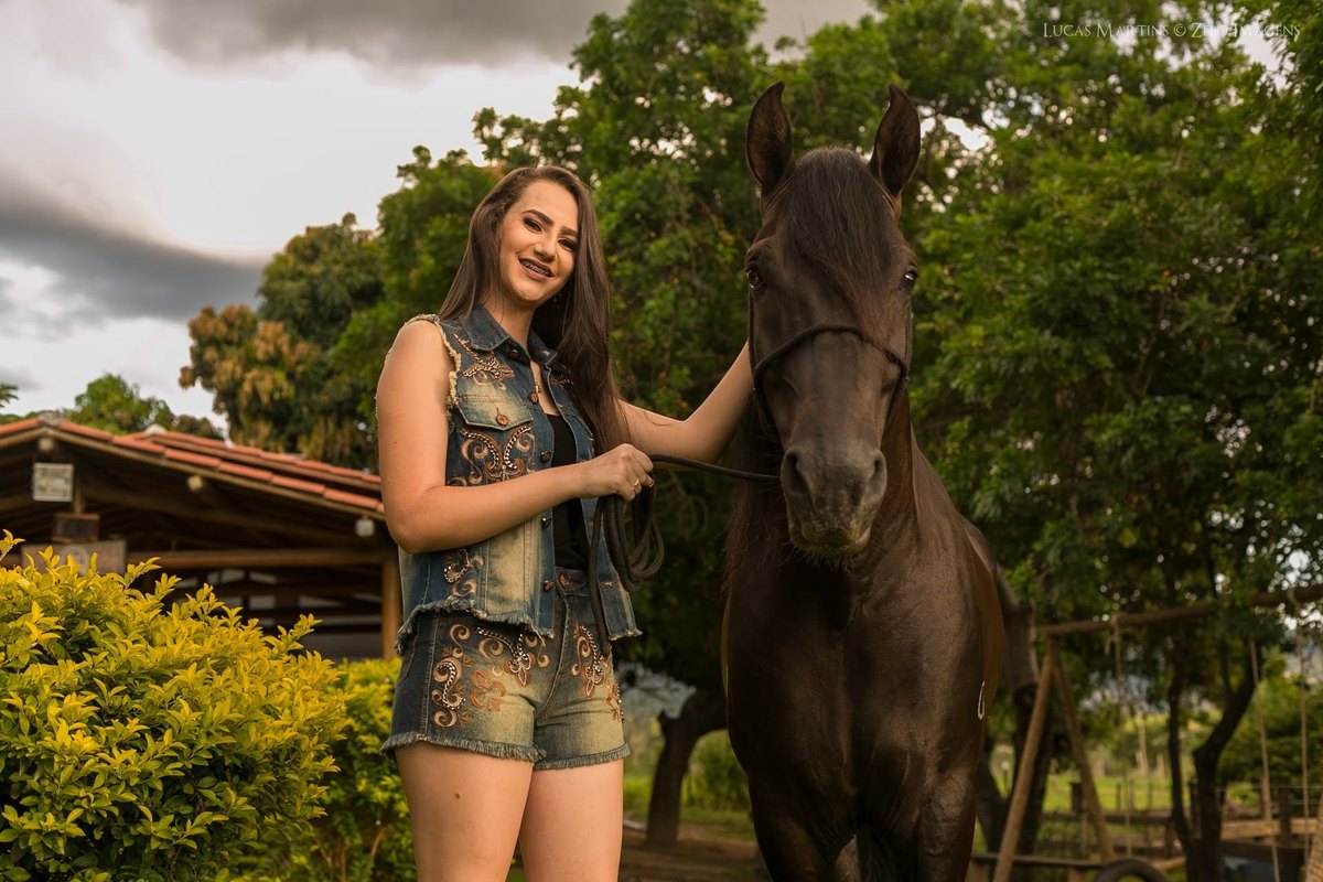 foto da debutante posando com cavalo em ensaio fotográfico 15 anos feito em Araçuaí - MG