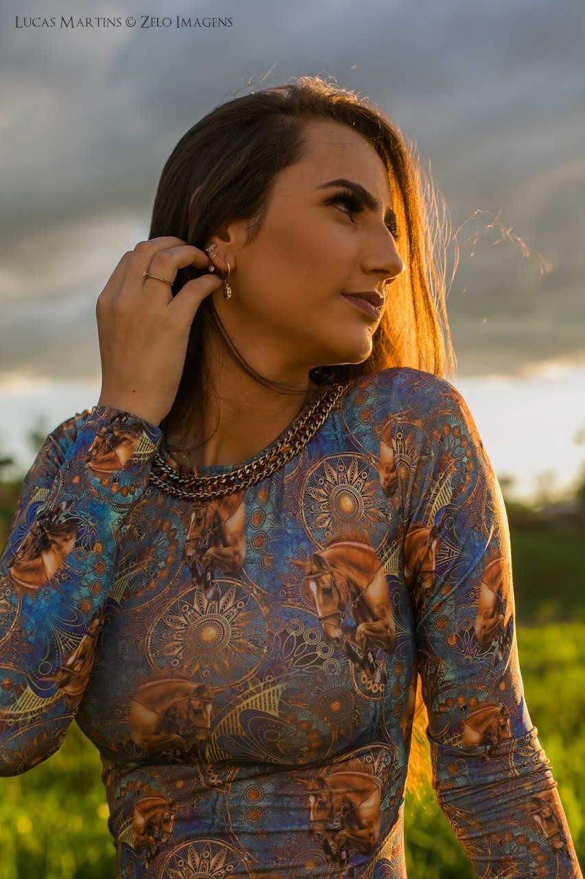 fotografia da debutante passando a mão no cabelo durante ensaio fotográfico 15 anos feito na cidade de Araçuaí - MG