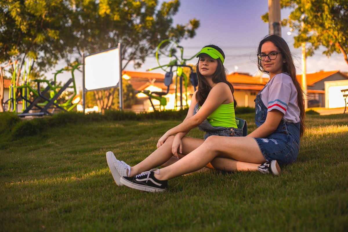 ensaio debutante junto com a miga sentada na grama