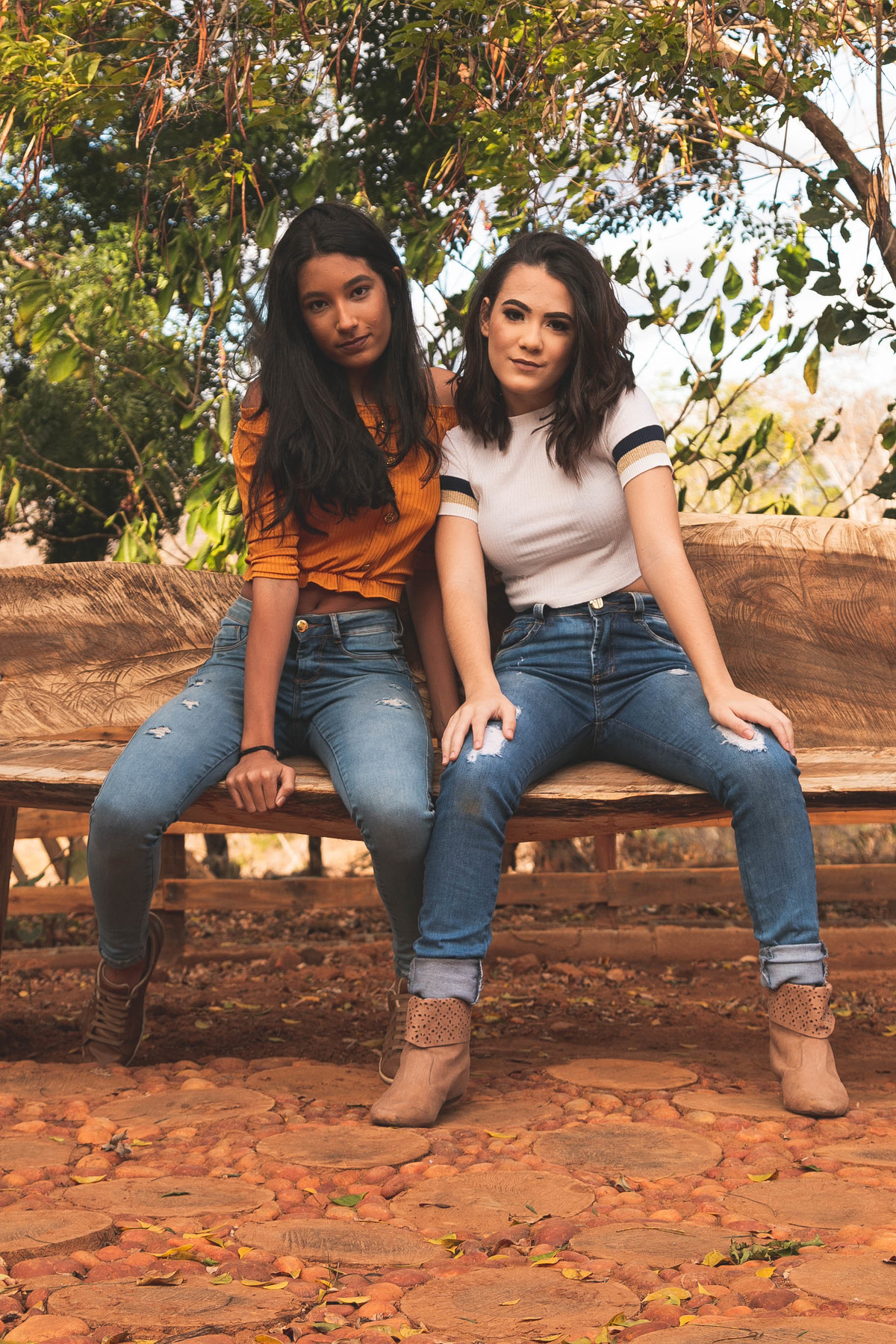 Debutante posa sentada em um banco de madeira no sítio ao lado da sua amiga