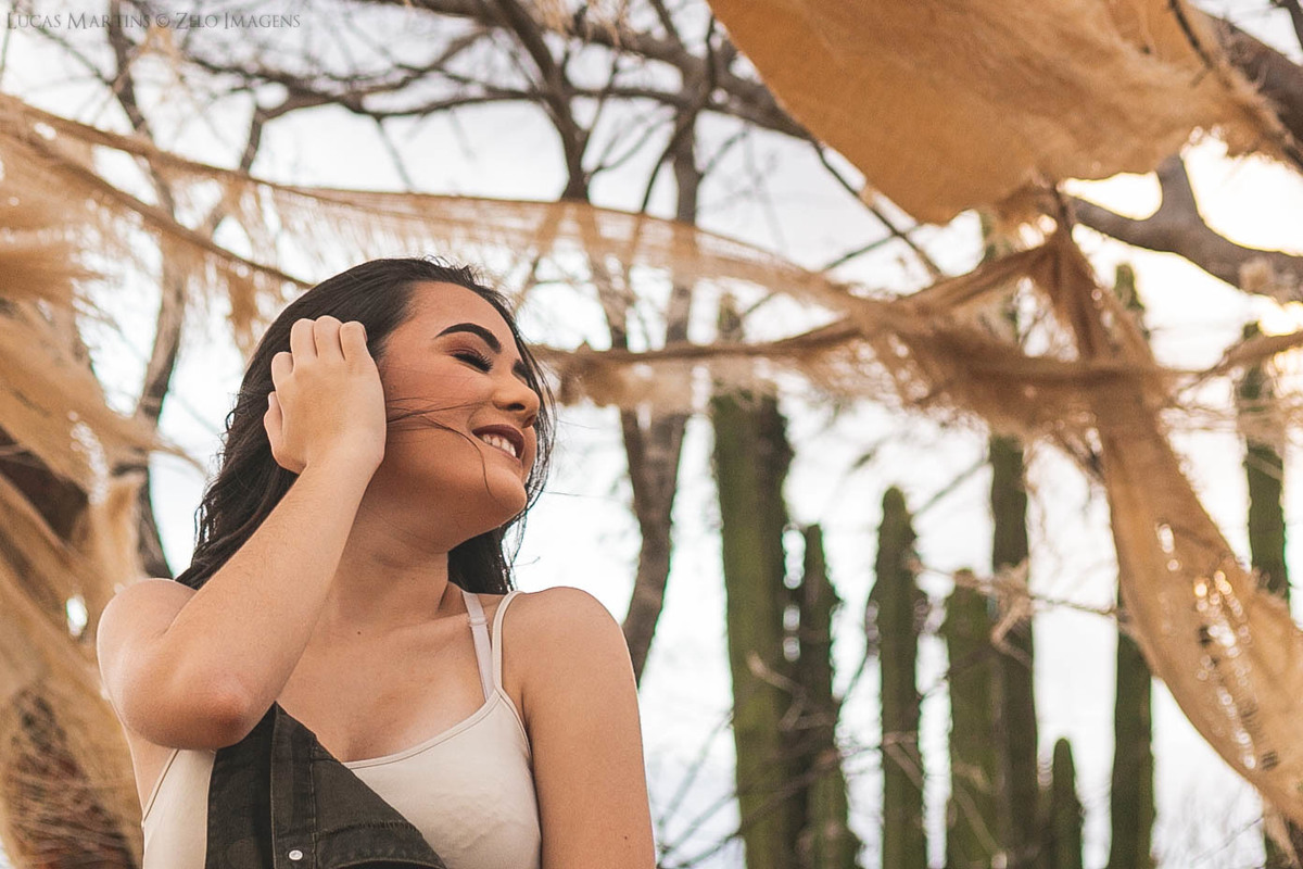 Debutante posa ao vento próximo ao uma barraca em ruinas